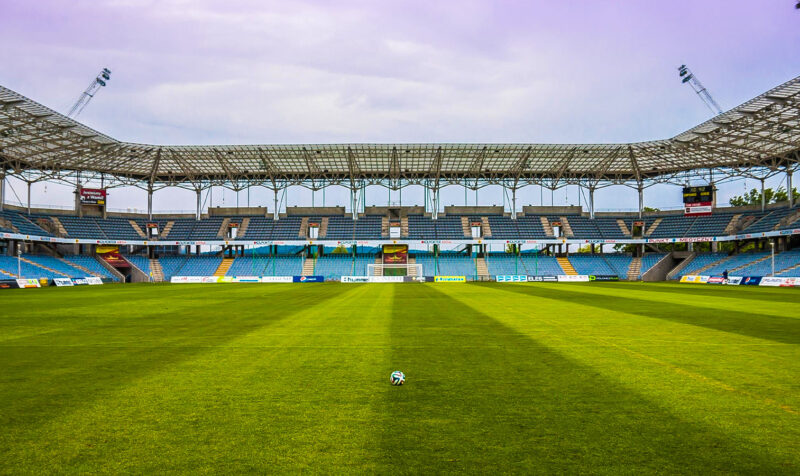 image of an empty soccer stadium with a lone ball in the middle