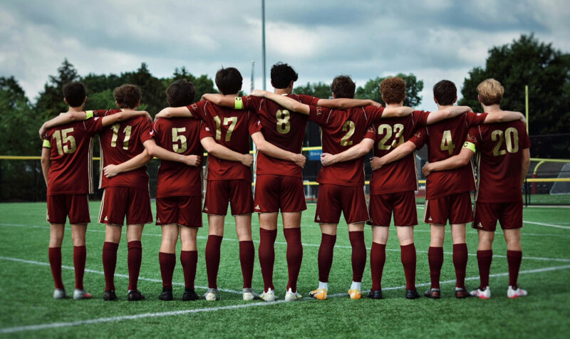 High school boys soccer team with arms around each other