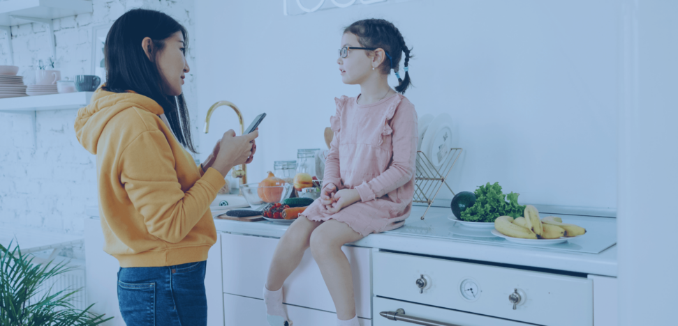 Image of mother reading message from teacher via cell phone to her child