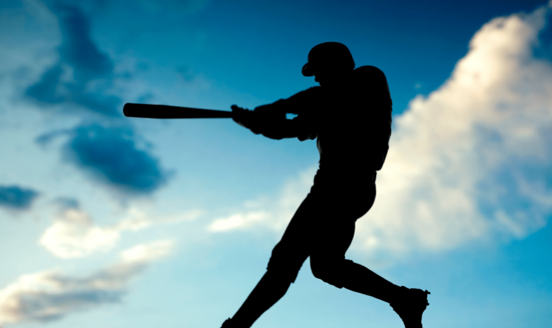 silhouette of batter swinging a bat