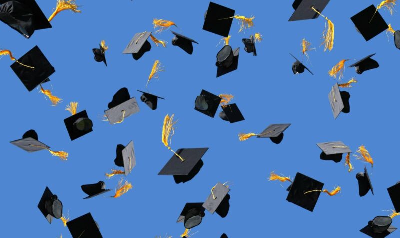 Graduation caps thrown in air