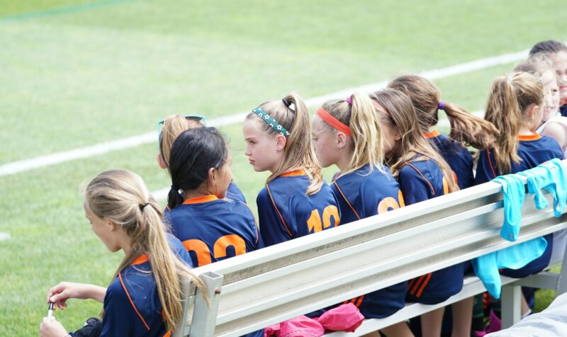 Girls athletic team sitting on bench
